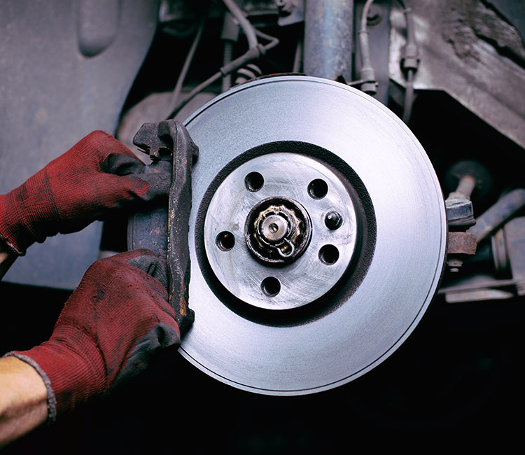 a man is fixing a broken up radiator  serviced by Brake Pros of Waltham in Arlington specializing in brake pad replacement.