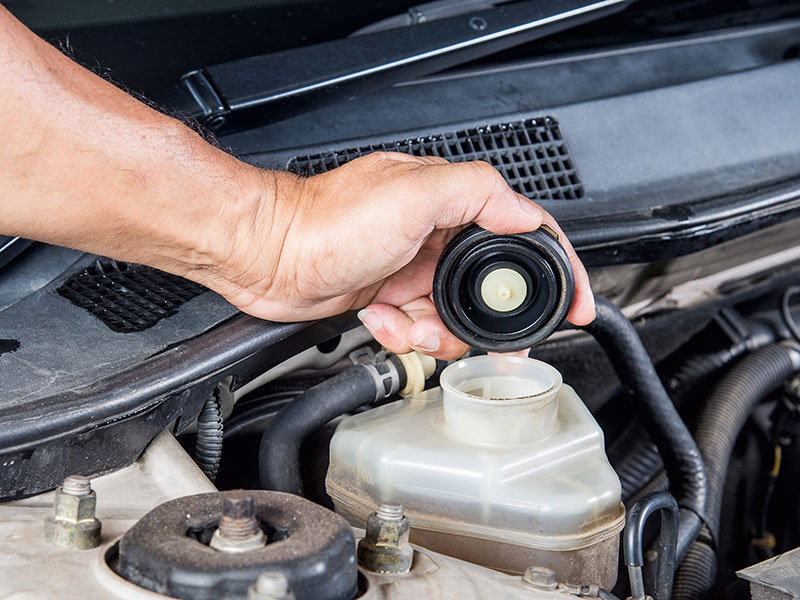 a person is using a remote control on a car  serviced by Brake Pros of Waltham in Waltham, MA specializing in caliper repair.