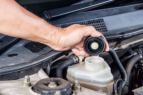 a person is using a remote control on a car  serviced by Brake Pros of Waltham in Billerica specializing in brake fluid change.