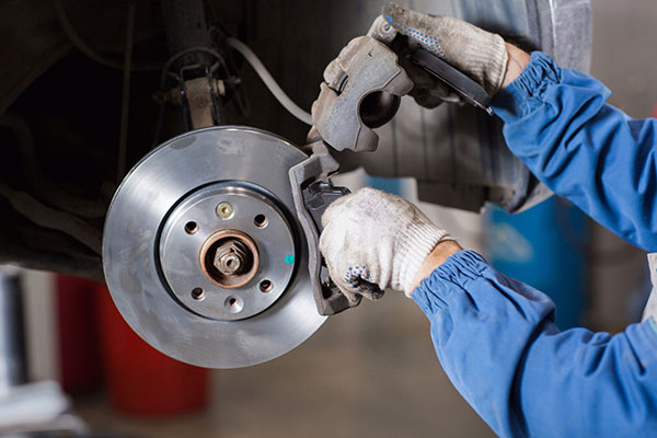 a man fixing a broken up motorcycle  serviced by Brake Pros of Waltham in Arlington specializing in brake pad replacement.