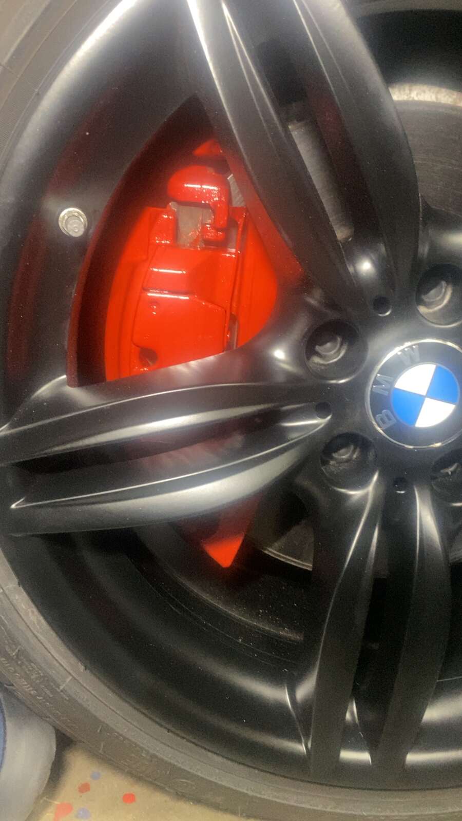 a red and black tire serviced by Brake Pros of Waltham in Waltham, MA specializing in German car brake specialist.