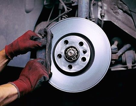 a man is fixing a broken up radiator  serviced by Brake Pros of Waltham in Waltham, MA specializing in caliper repair.